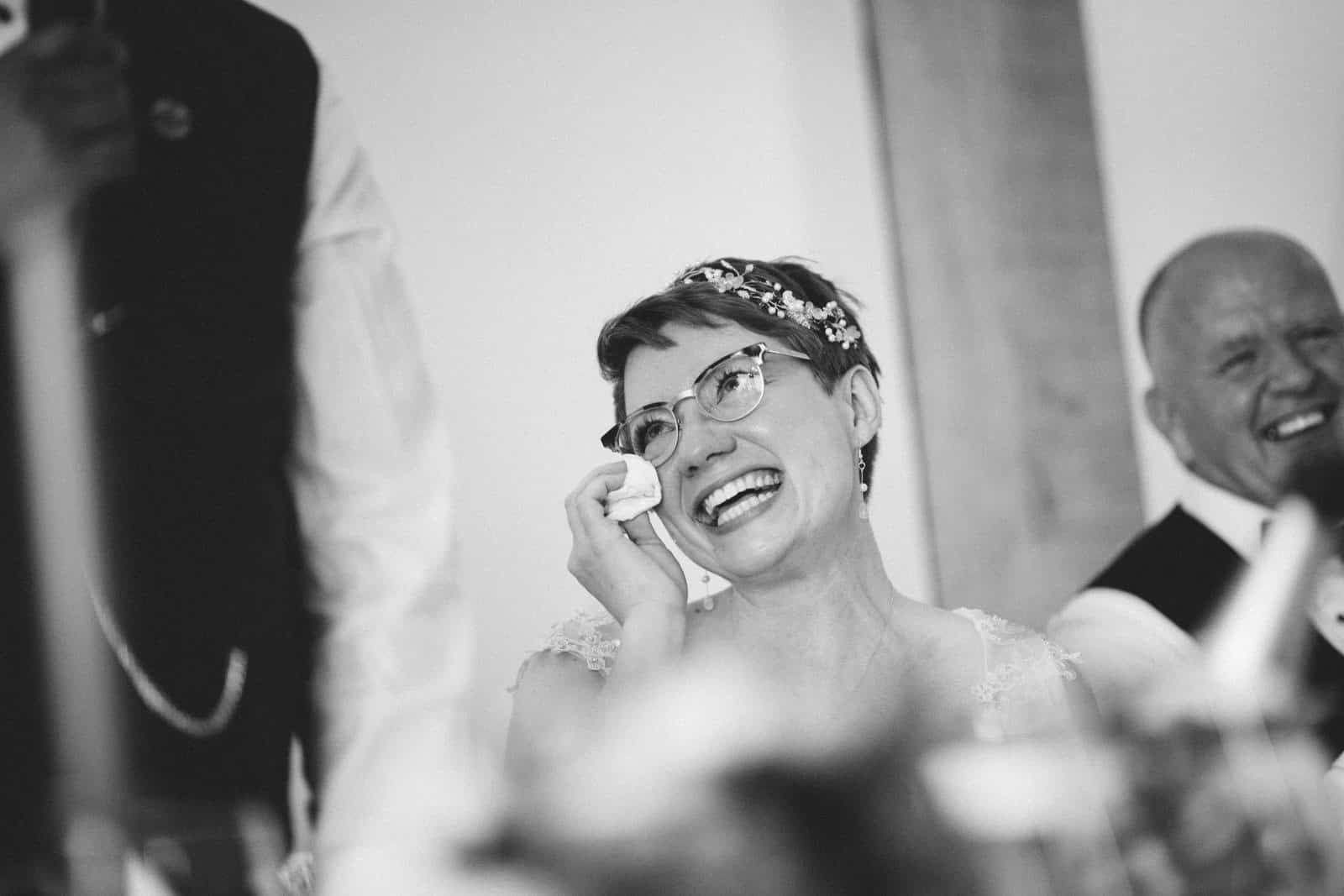 A bride is crying during her wedding speech captured by a Dodford Manor Wedding Photographer.