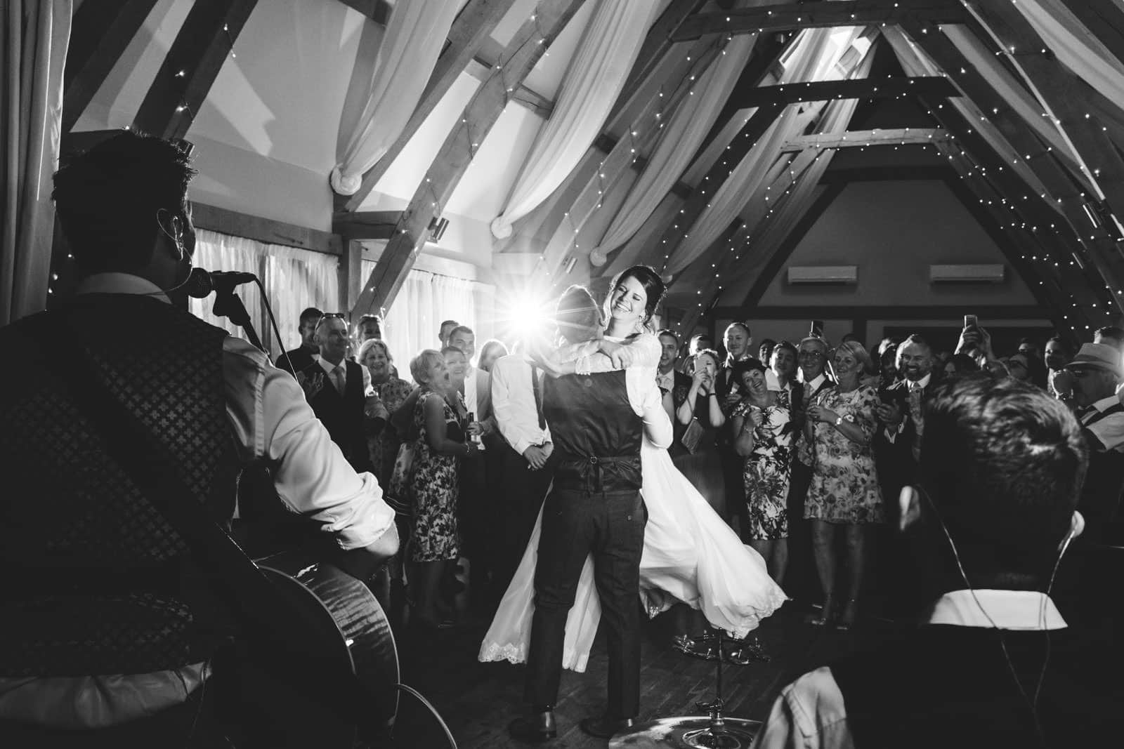 Beautiful first dance wedding photography moment as the bride is lifted up