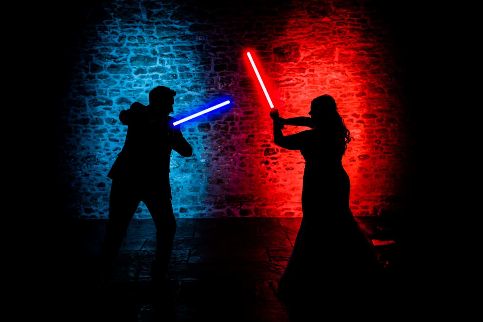 Star Wars Themed Wedding photo of Couple playing with lightsabers